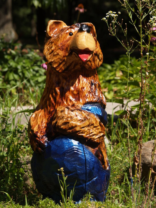 Bear in blue overalls in the grass